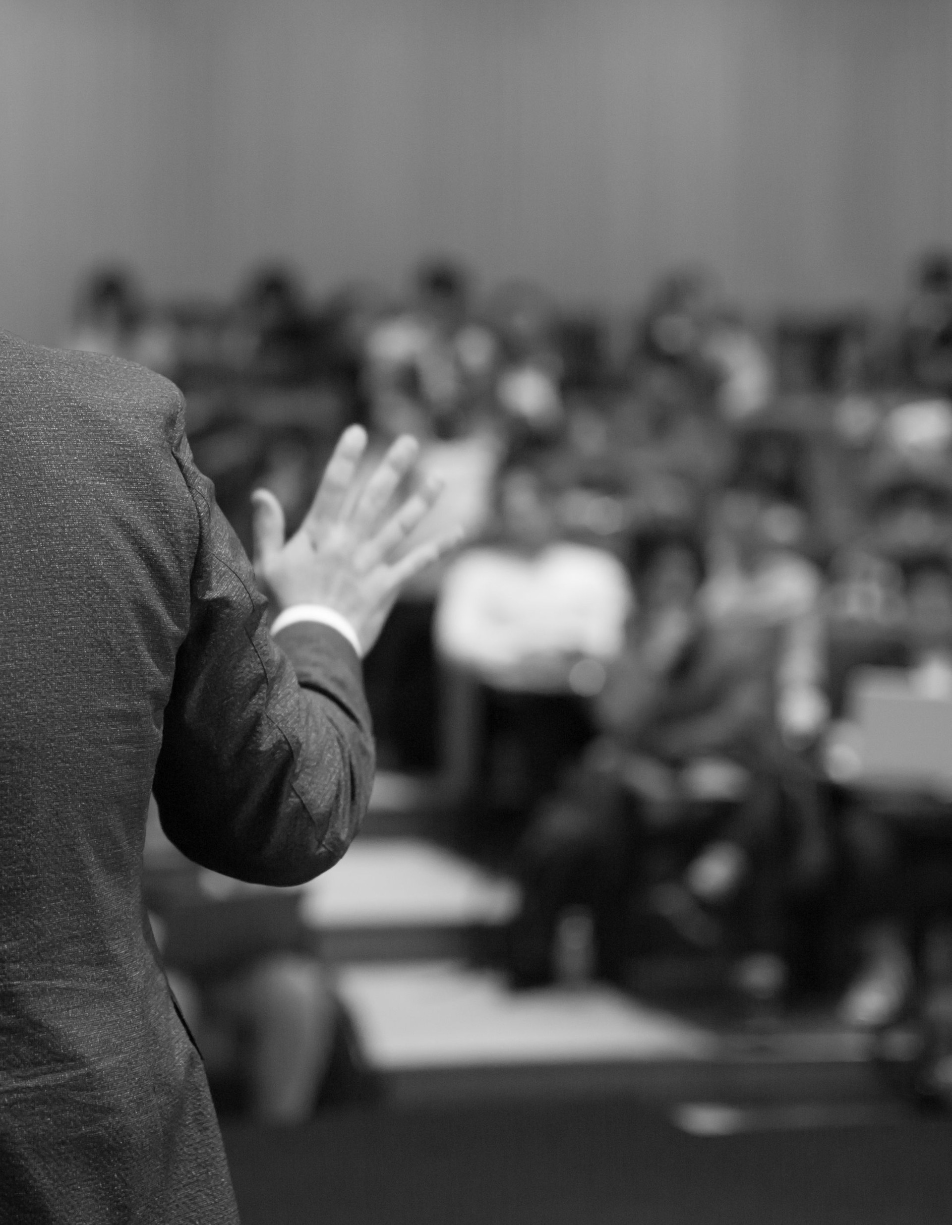 Business coach. Team leader teaches employees at a business meeting in a conference room. Speaker giving a talk at a corporate business seminar. Audience in hall with presenter in lecture photo.