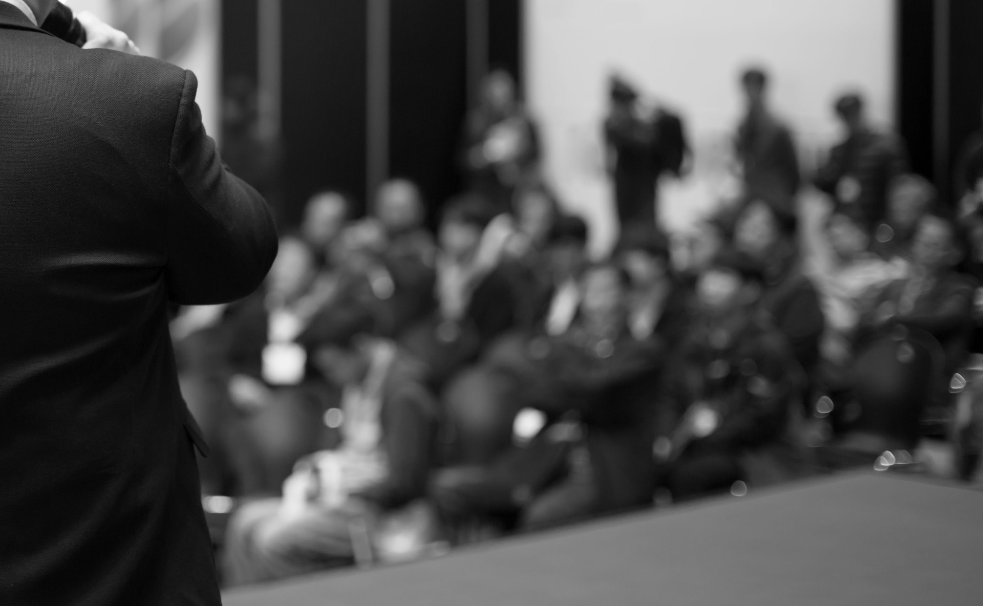 Business People Meeting and Working while Business Executive Lead Presenter Speaks to Group of Successful Technology Entrepreneurs. Consultant Advisor. Growth Training Lecture. Defocused Blurred